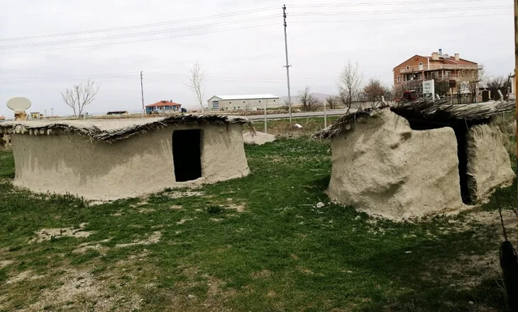 Yan yana iki oval kerpiç evin dış görünümü