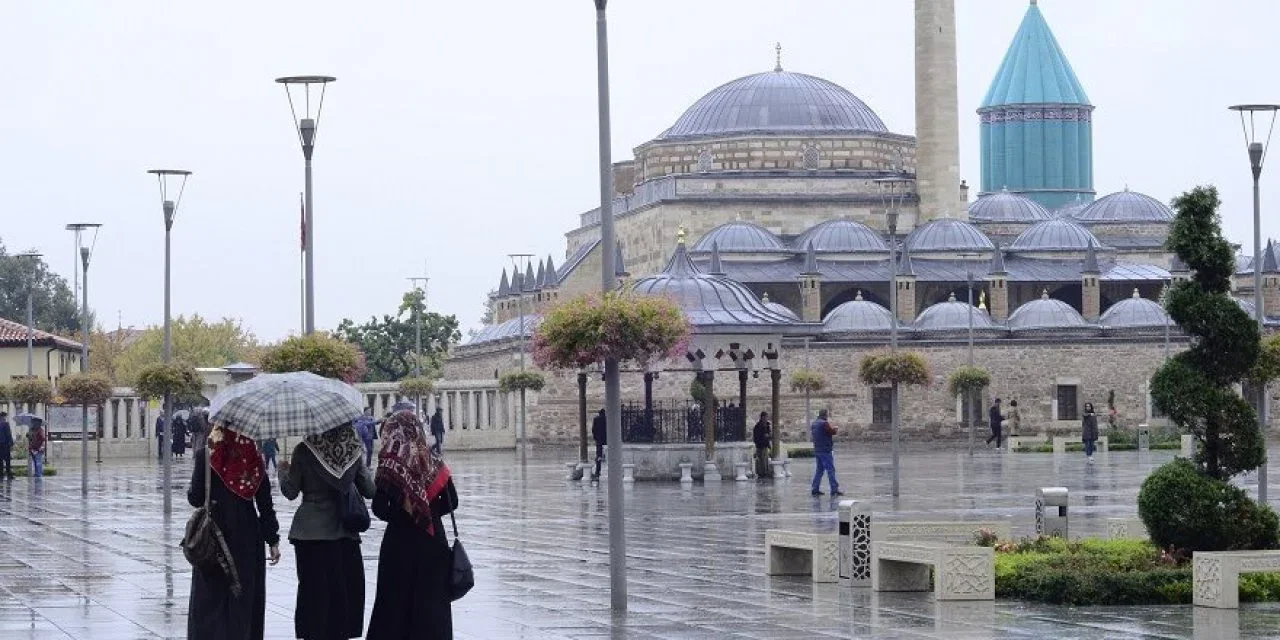 Yağmurlu bir günde Mevlâna Meydanı, şemsiyeli yayalar ve Yeşil Kubbe