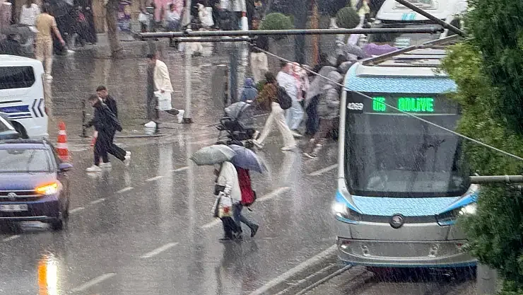 Yağmurda Konya sokağında tramvay ve yayalar