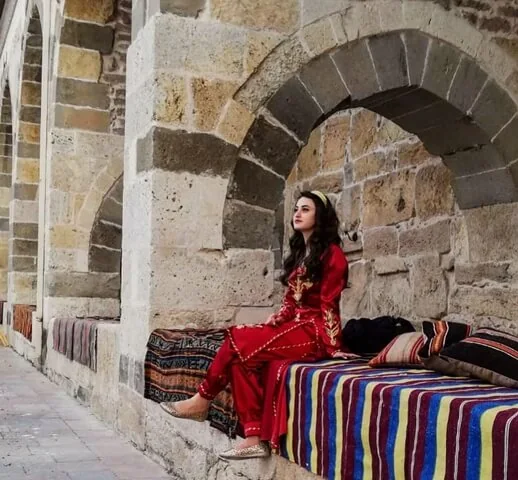 Kemerli bir nişte kırmızı bindallı giymiş genç kız